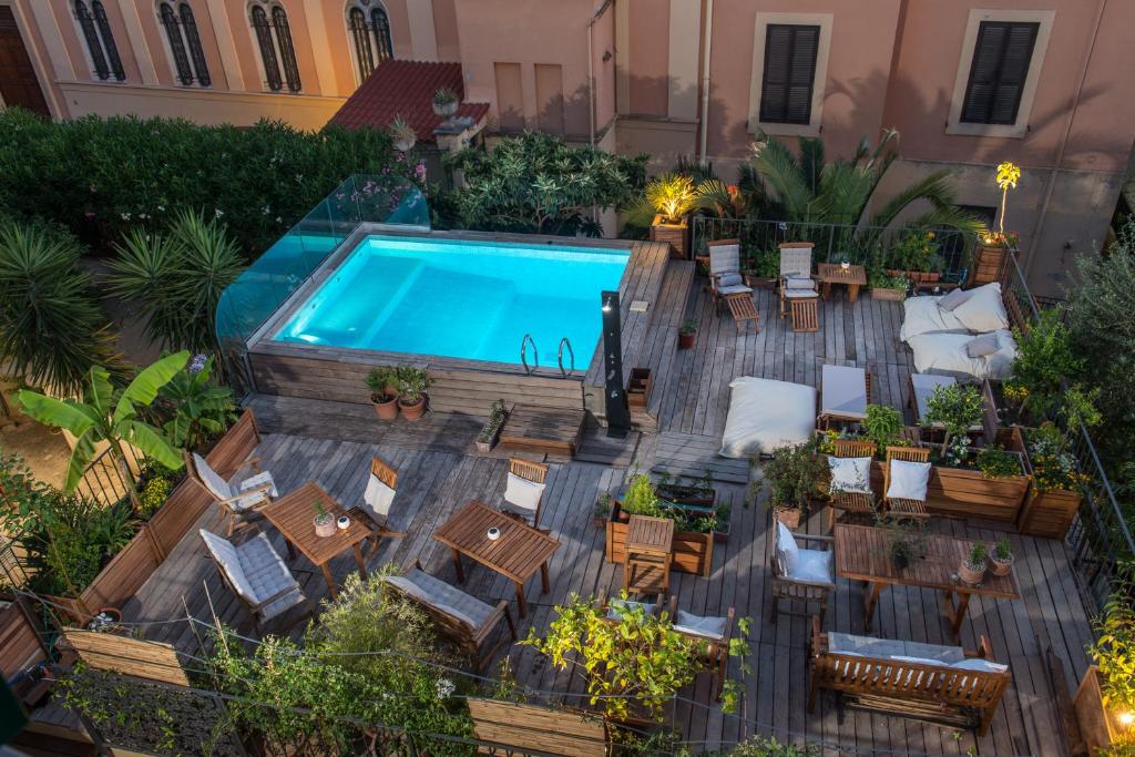 einen Blick über einen Pool mit Tischen und Stühlen in der Unterkunft Palm Gallery Hotel in Rom