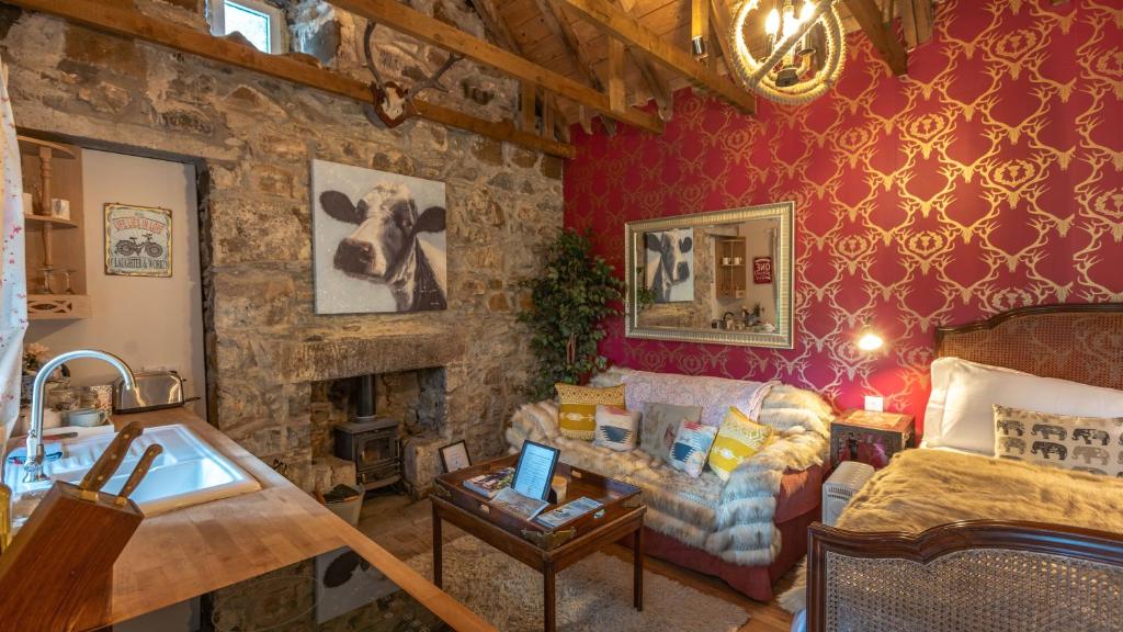 a living room with a couch and a stone wall at Glamping Bothie in Inverurie