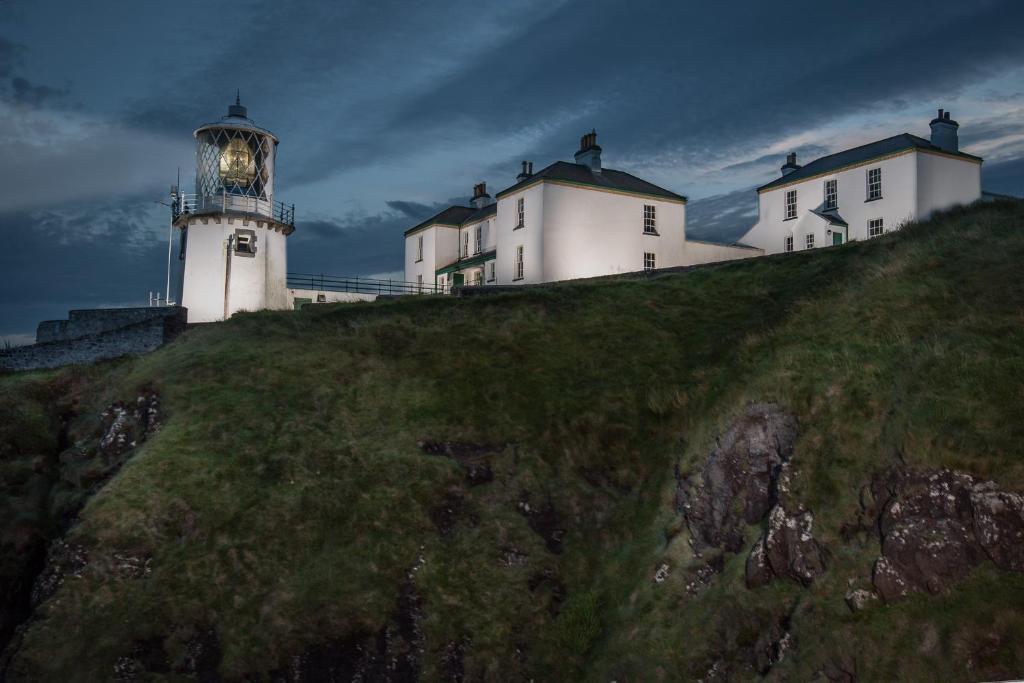 two white lighthouses sitting on top of a hill at Blackhead Lighkeeper's Houses, Antrim in Whitehead
