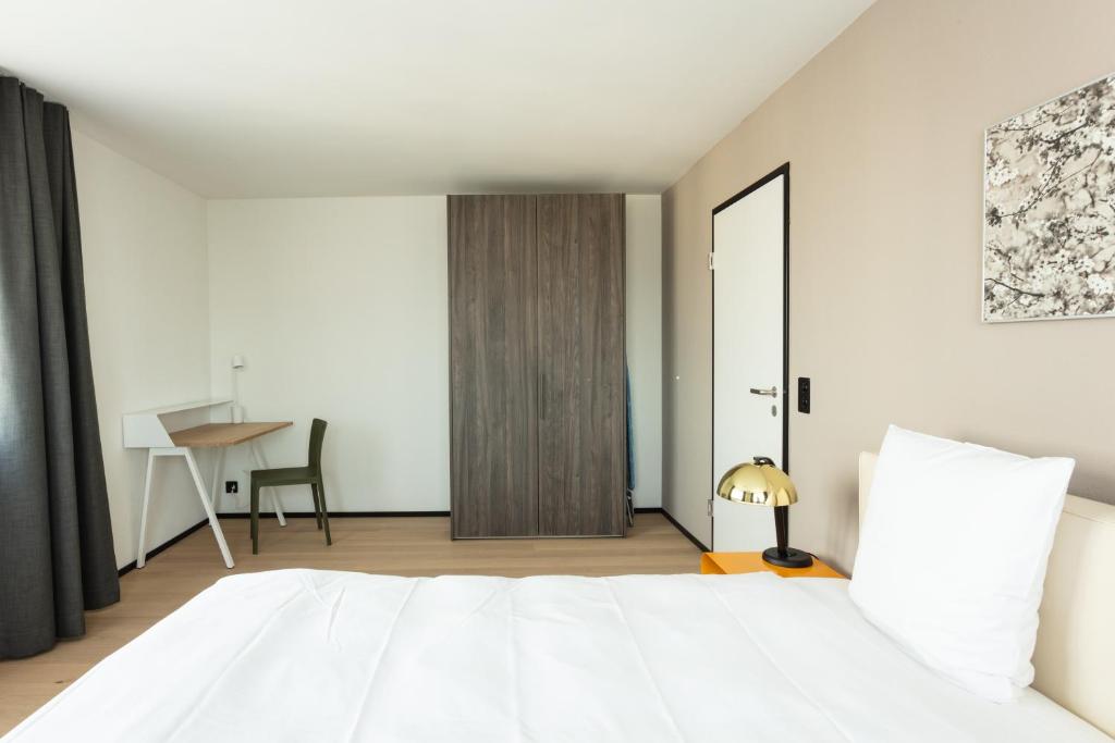 Postel nebo postele na pokoji v ubytování EMA House Serviced Apartments Superior Downtown