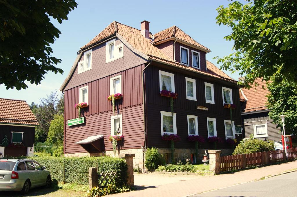 ein großes Holzhaus mit einem roten in der Unterkunft Gästehaus Wetzel in Braunlage