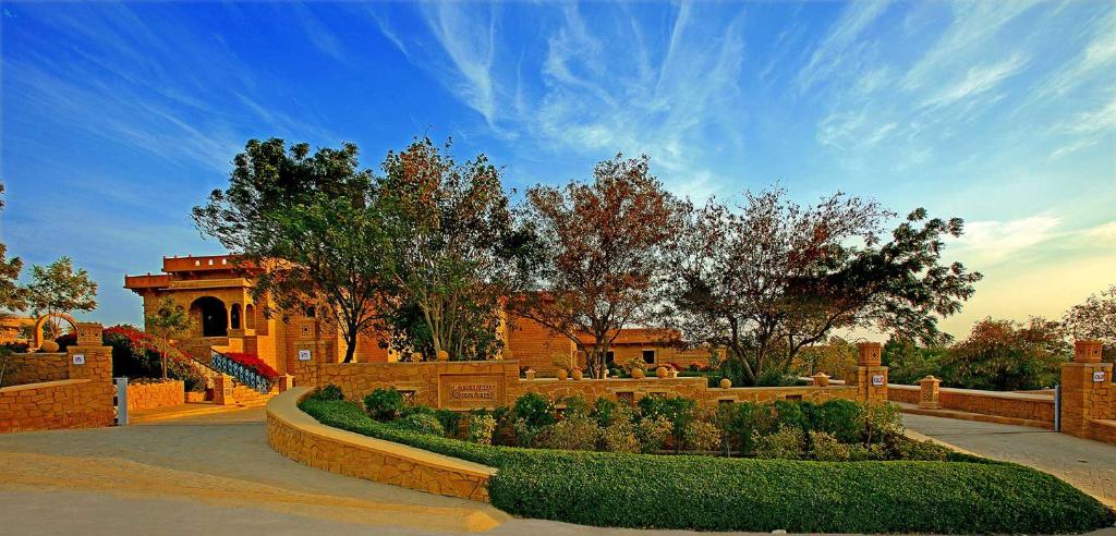 齋沙默爾的住宿－Hotel Rawalkot Jaisalmer，一座灌木丛和树木的花园以及一座建筑