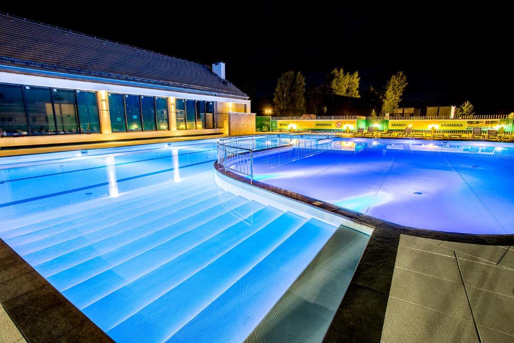 una grande piscina di notte con un edificio di Feniks Apartamenty - Sun Club SPA a Kołobrzeg