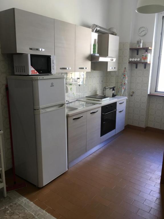 kuchnia z białymi szafkami, zlewem i kuchenką w obiekcie Appartamento - Casa vacanza Nonna Grazia w Rzymie