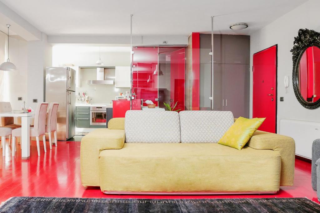 a living room with a yellow couch and a kitchen at By Best Apartments in Tirana