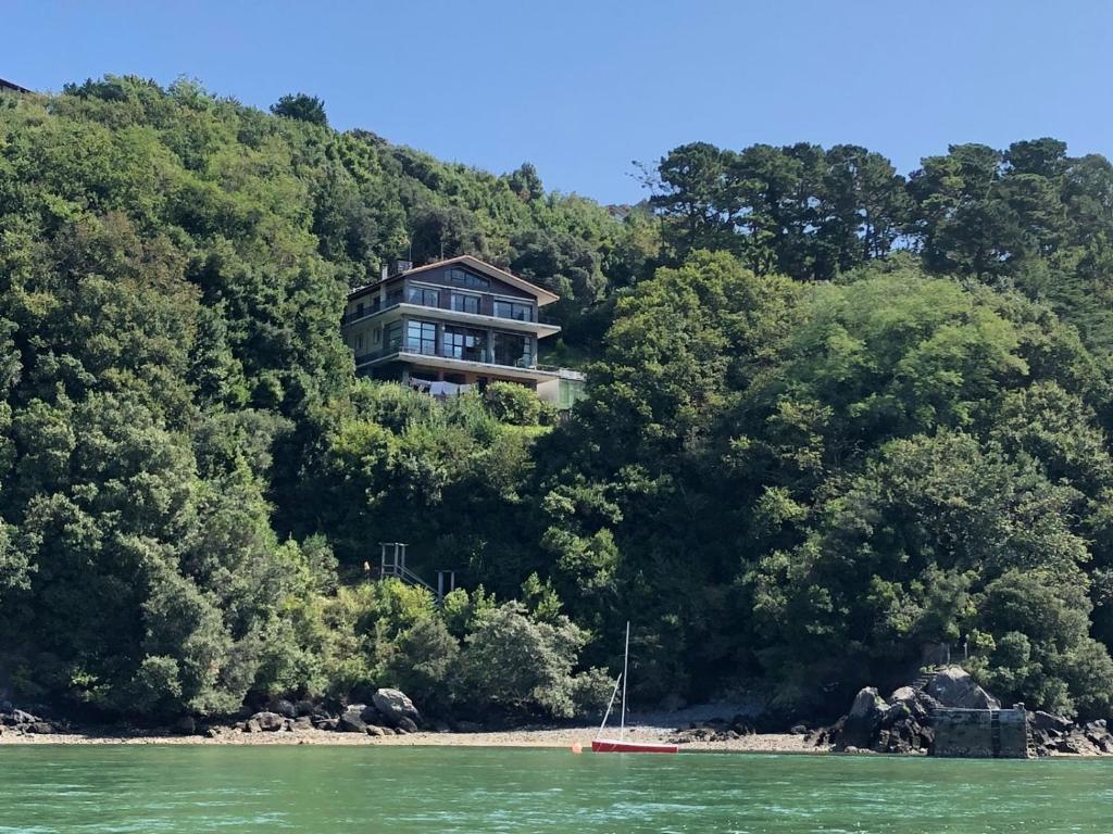 a house on the side of a hill with trees at Kizkitza in Gautegiz Arteaga