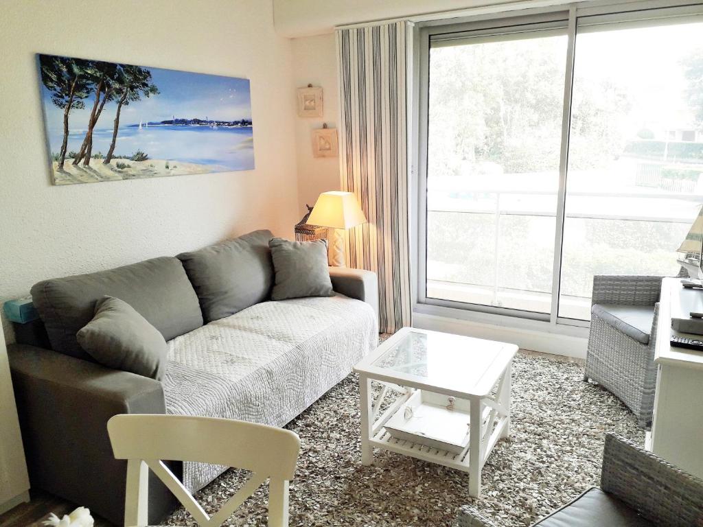 a living room with a couch and a large window at B13 Appartement avec Parking proche Plage in Arcachon