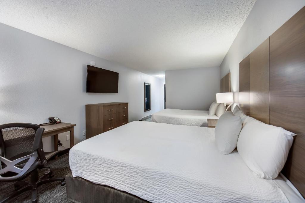 een slaapkamer met een bed, een bureau en een stoel bij Red Lion Inn & Suites Grants Pass in Grants Pass