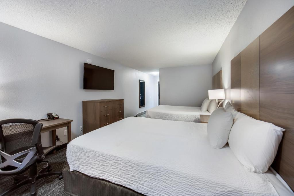 sypialnia z łóżkiem, biurkiem i krzesłem w obiekcie Red Lion Inn & Suites Grants Pass w mieście Grants Pass