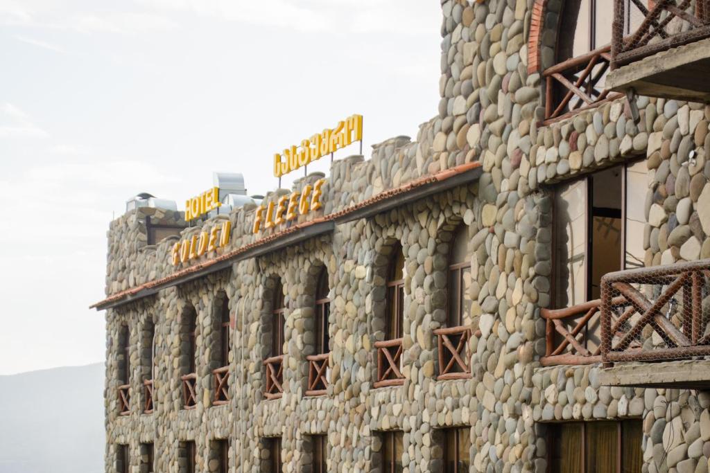 un edificio de piedra con un cartel encima en Golden Fleece, en Mtskheta