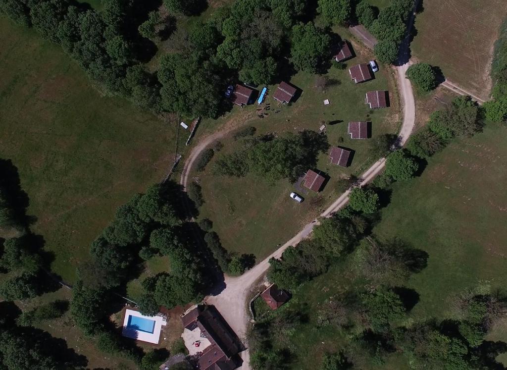 une vue aérienne sur une ferme avec des maisons et une route dans l'établissement Village de Chalets de Rocamadour, à Rocamadour