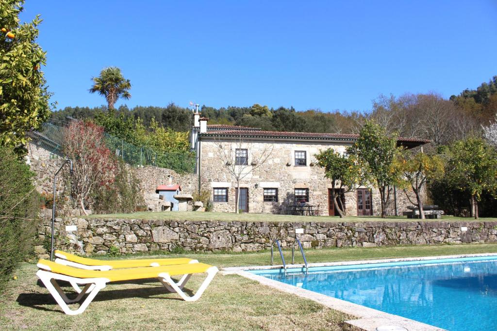 a pool with a yellow bench next to a house at Quinta do Sardão in Boticas