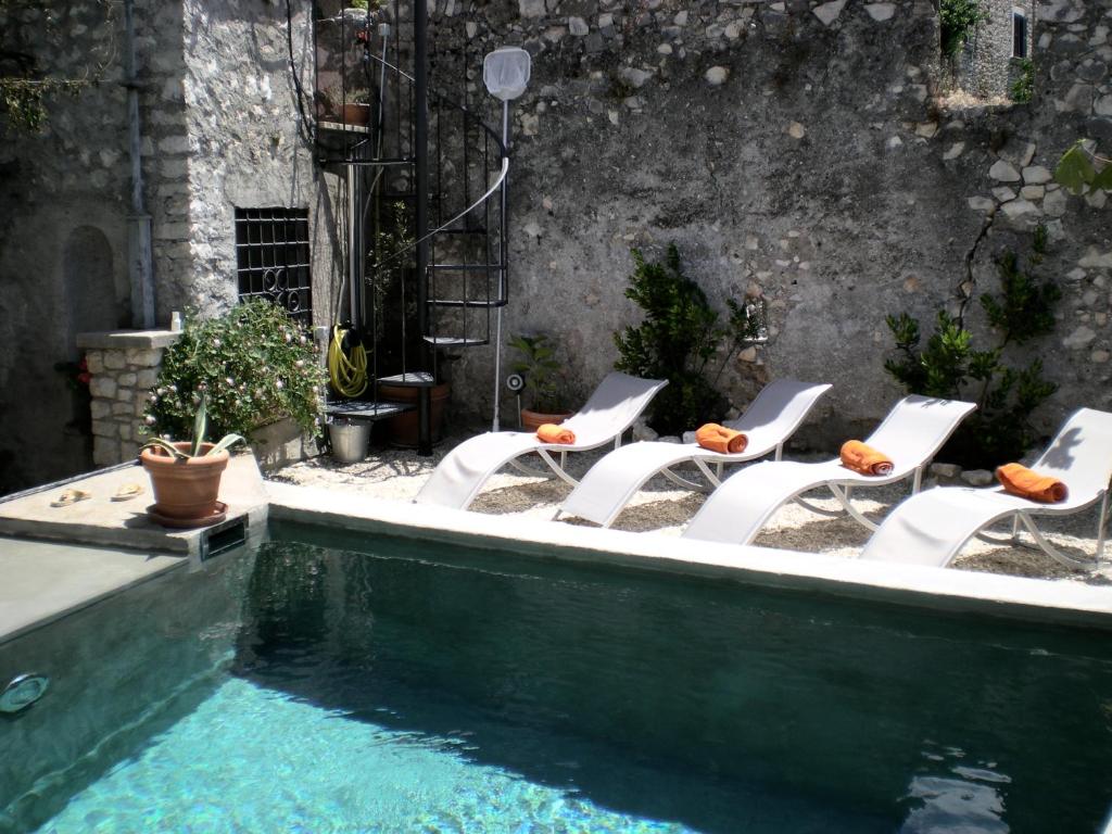 - un groupe de chaises assises à côté de la piscine dans l'établissement Domus Doull, à Sermoneta