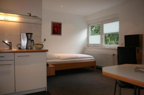 ケルンにあるApartment-Hausのベッドとキッチン付きの小さな部屋