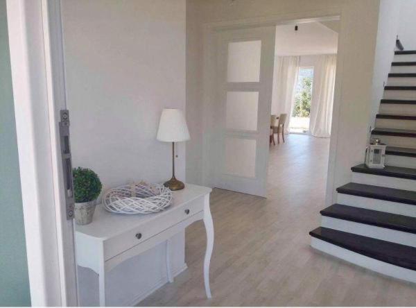 uma sala de estar branca com uma mesa com um candeeiro e escadas em Villa Renata Mit außen Pool em Capljina