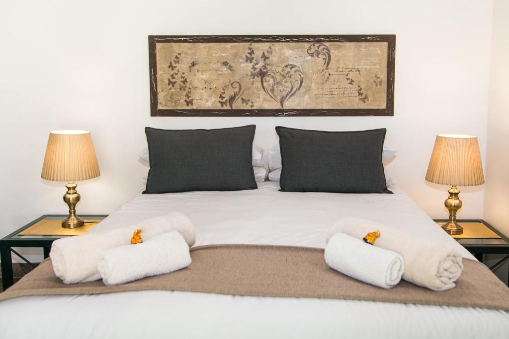 a bedroom with a large white bed with two lamps at El Shadai Guest House in Thabazimbi