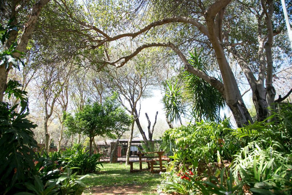 a park with a picnic table and trees at Maroela Gardens Guesthouse in Thabazimbi