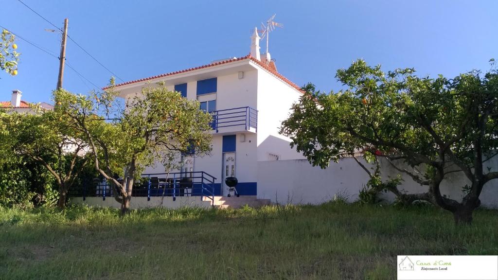 une maison blanche avec des arbres devant elle dans l'établissement Casa D'Avó (R/C), à Altura