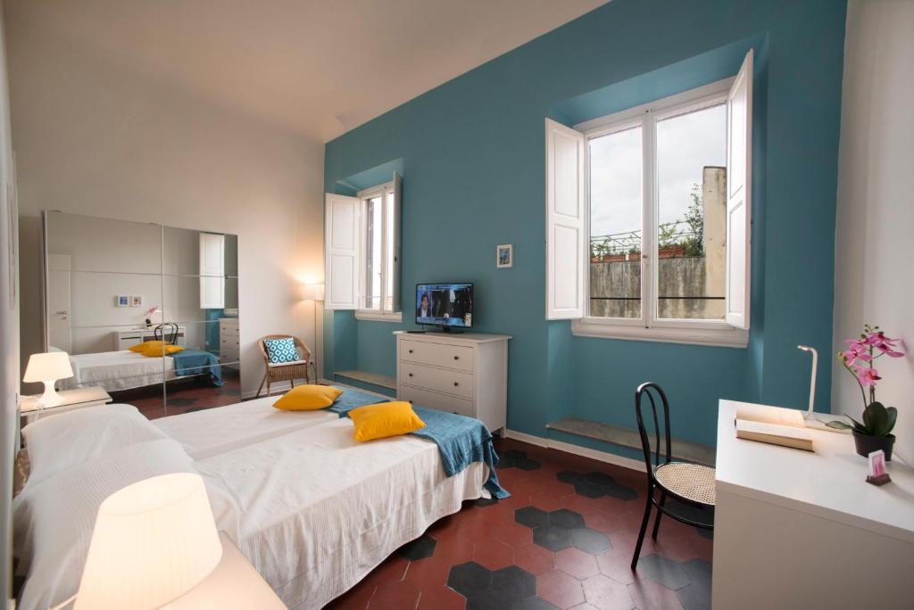 una camera da letto con pareti blu e un letto con cuscini gialli di Florence Oasis a Firenze