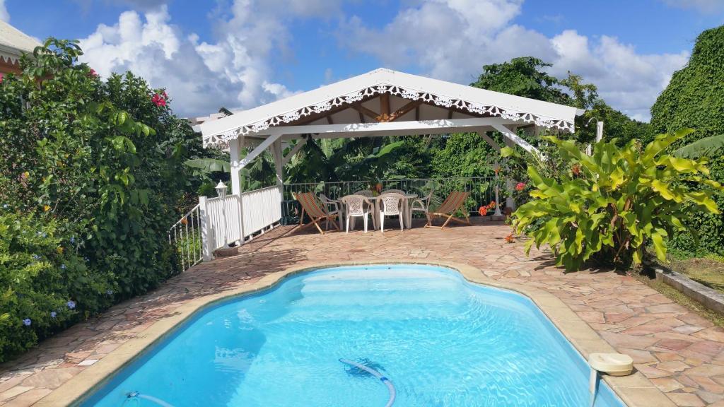 a swimming pool with a gazebo in a backyard at Mary Madinina in Fort-de-France