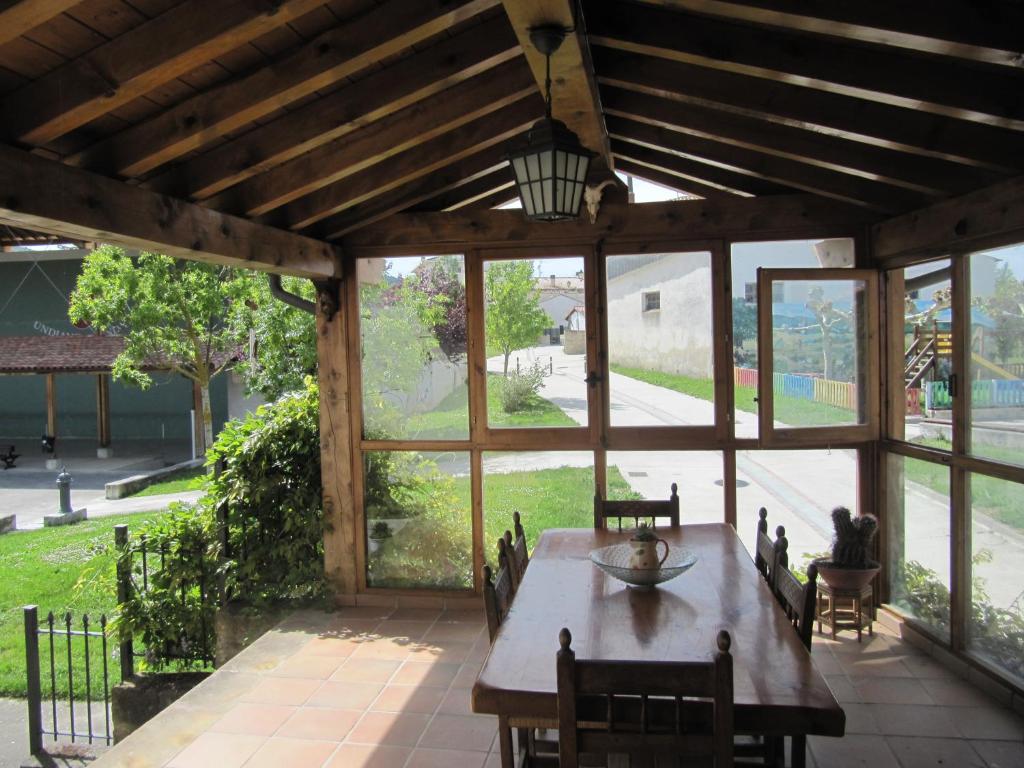 a large screened porch with a wooden table and chairs at Altikarra I in Undiano