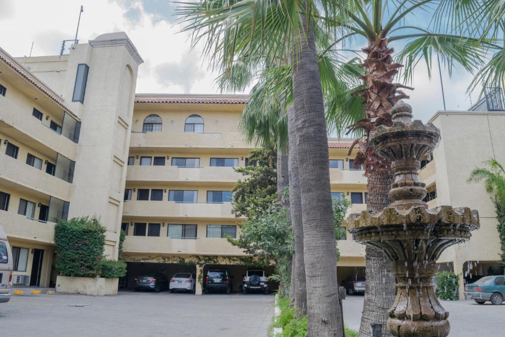 una palmera frente a un edificio en Hotel America, en Tijuana