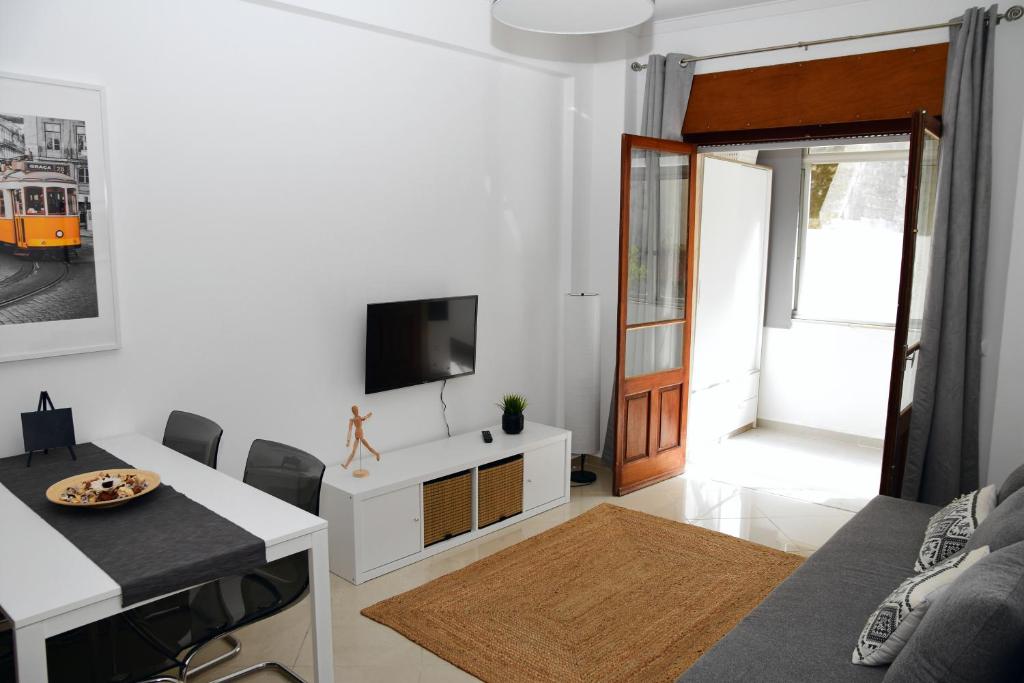 リスボンにあるGiestal Terraceの白いリビングルーム(テレビ、テーブル付)