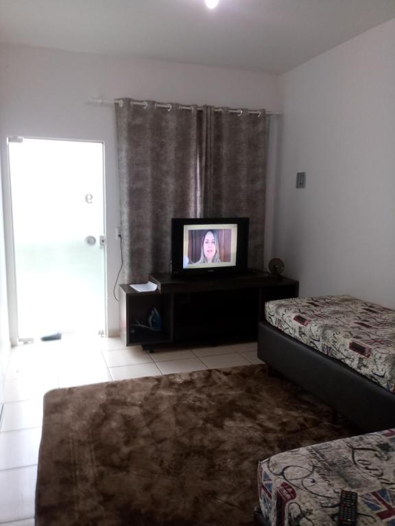 een woonkamer met 2 bedden en een televisie bij Apartamento Exclusivo - Hospedes in Joinville