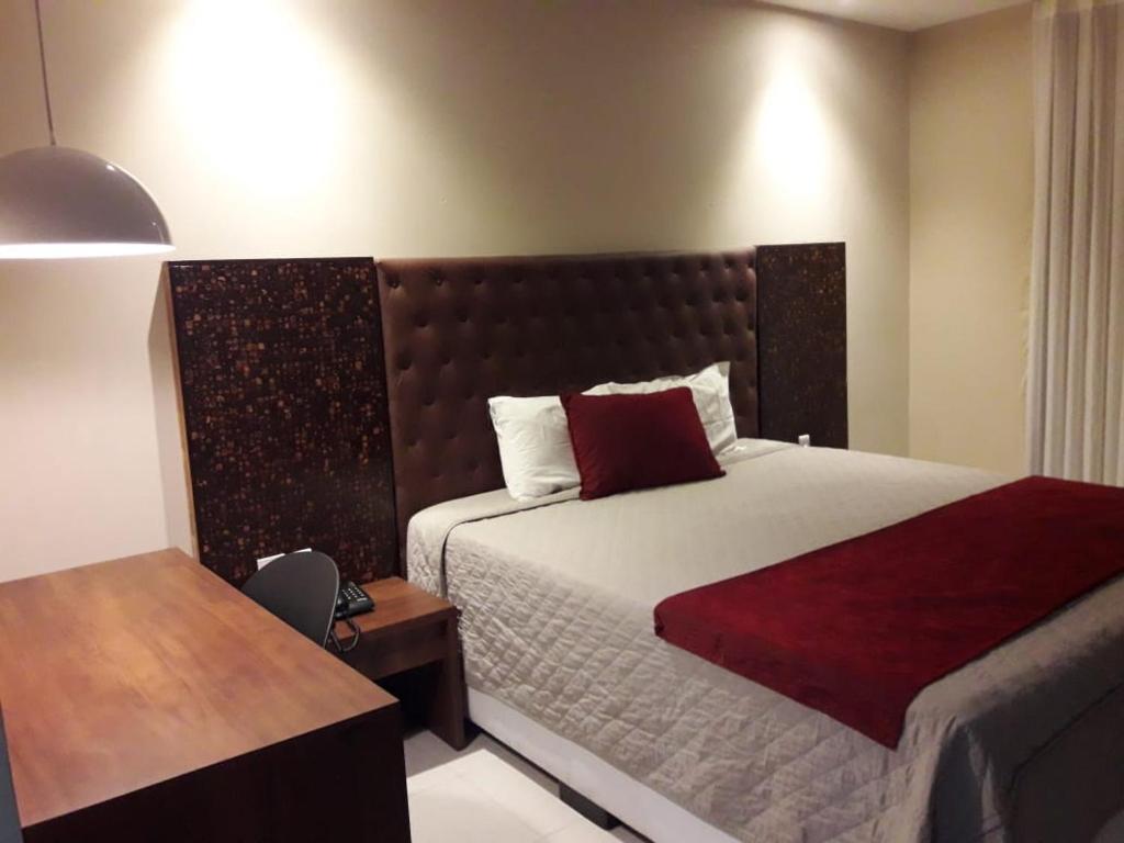 1 dormitorio con cama grande, escritorio y cama sidx sidx sidx sidx sidx sidx en Hotel Village Toritama, en Toritama