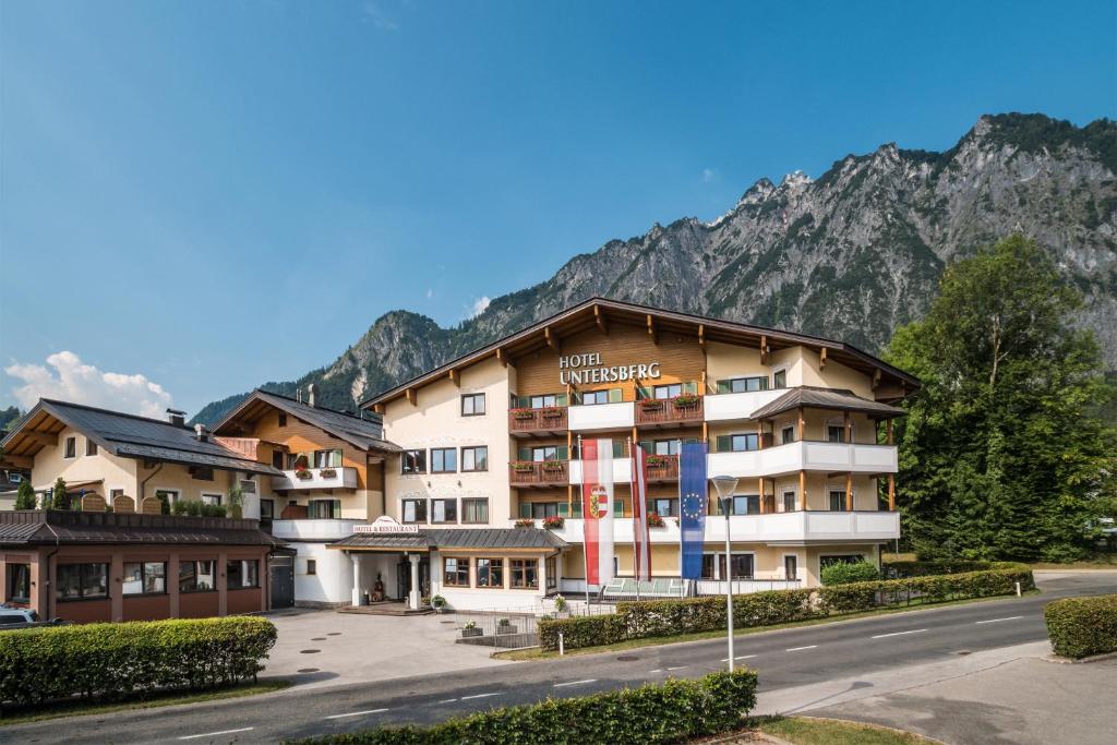 a large hotel with mountains in the background at Hotel Untersberg in Sankt Leonhard