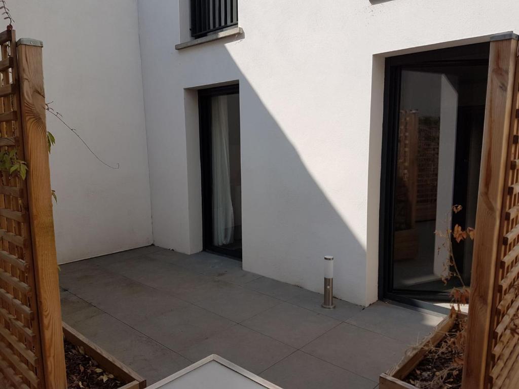 a room with a white wall and a patio at 003 - Appartement Moderne et Terrasse - Jeanne d&#39;Arc, Toulouse in Toulouse