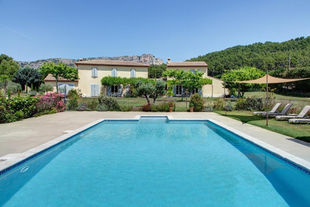 a swimming pool in front of a house at Les Grandes Terres - Gîtes & SPA in Mérindol