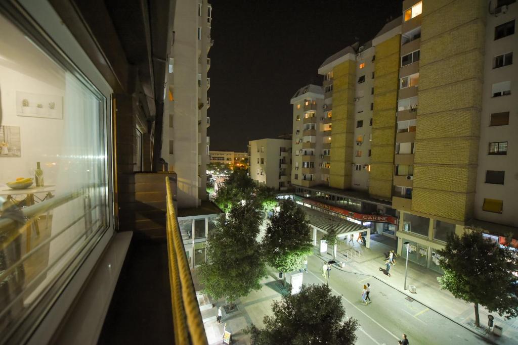 una vista desde una ventana de una ciudad por la noche en Korzo apartmani en Podgorica