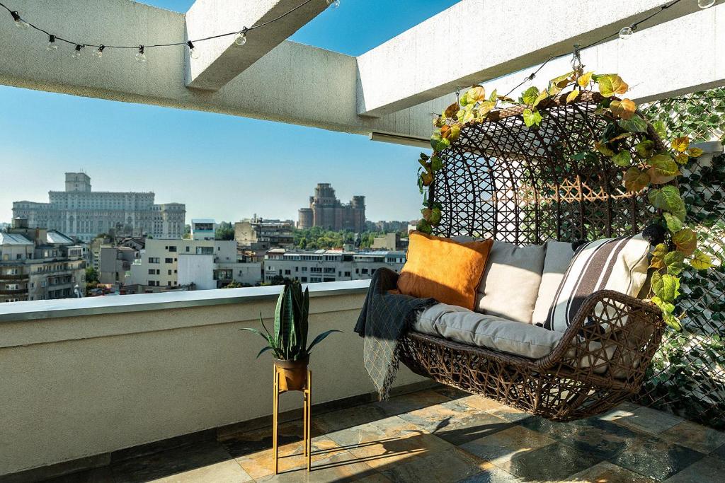 een stoel op een balkon met uitzicht op de stad bij Qult - Up in the Sky in Boekarest