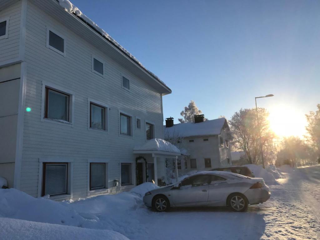 a car parked next to a building in the snow at E-City B&B in Tornio