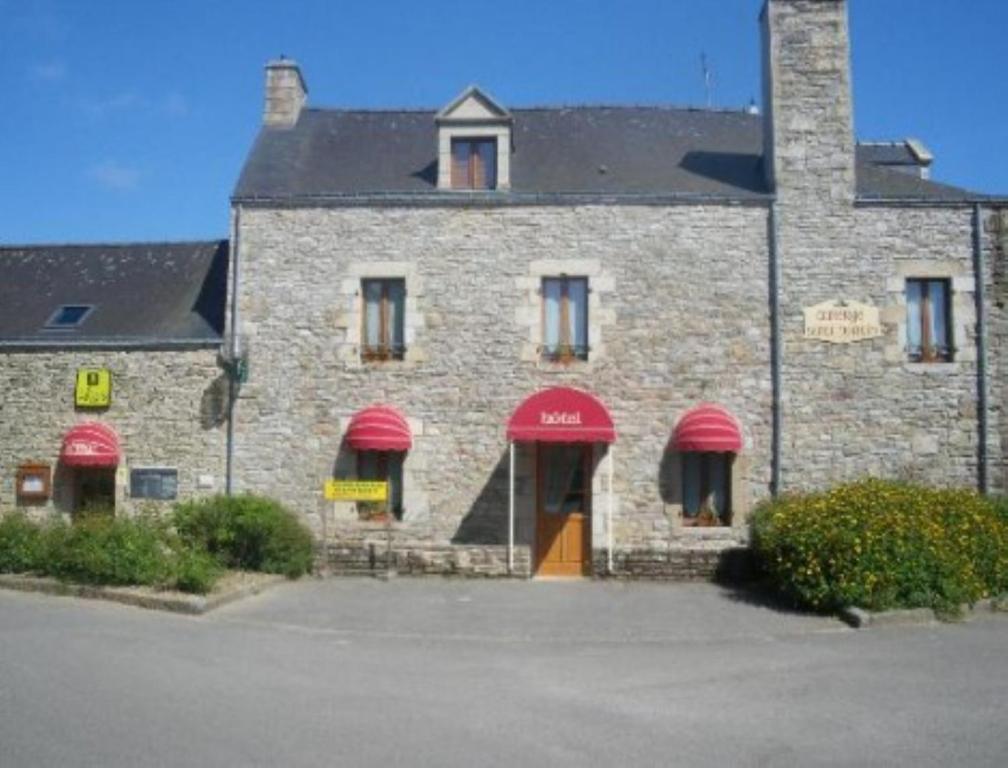 a brick building with red awnings on it at Auberge Saint Hernin in Pluherlin