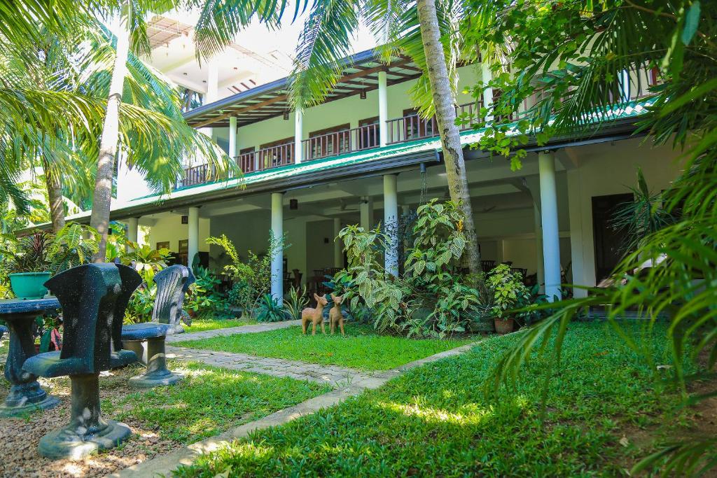 ウェリガマにあるTinara River Inn, Weligamaの犬2頭が立つ家