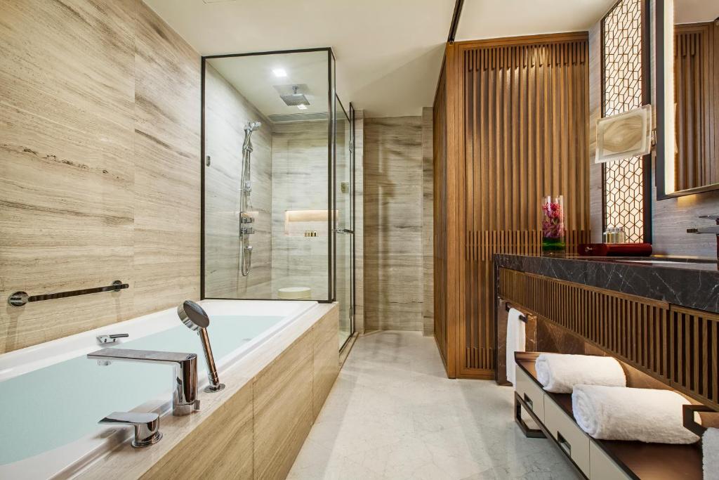 a bathroom with a tub and a shower at Ascott Riverside Garden Beijing in Beijing