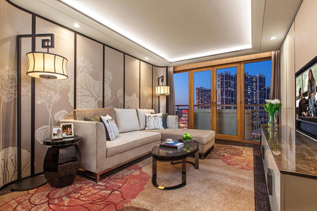 a living room with a couch and a large window at Ascott Riverside Garden Beijing in Beijing