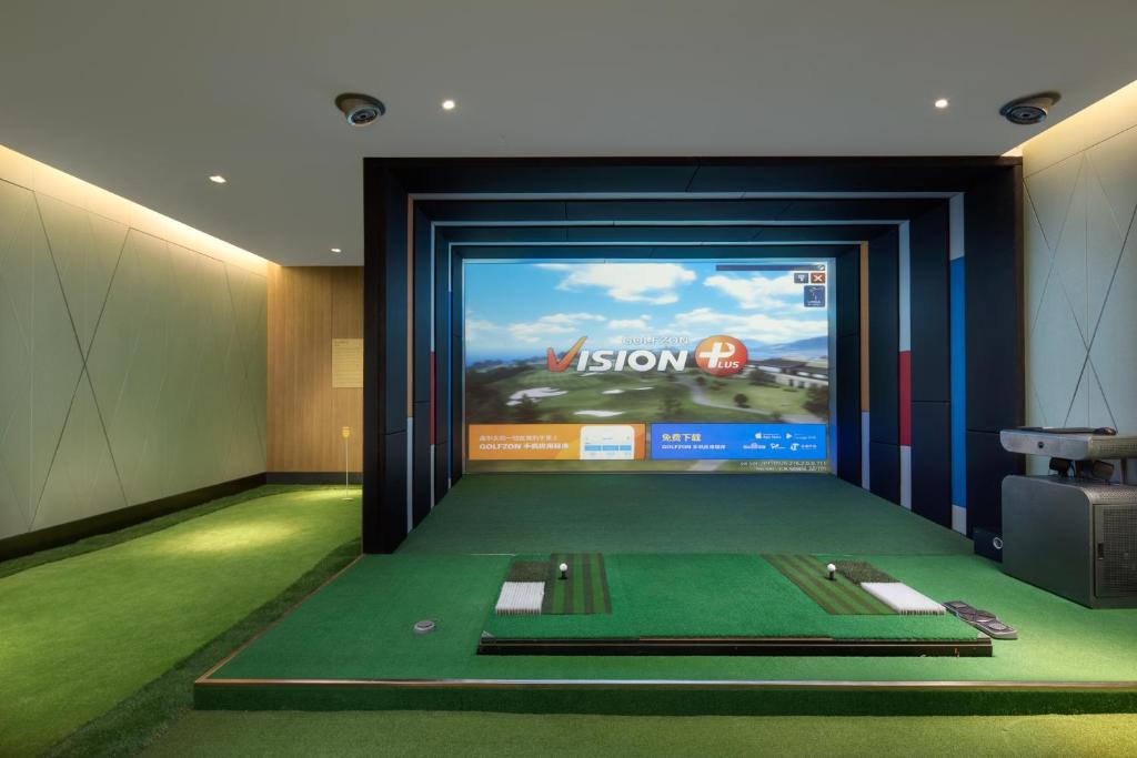 a room with a television and a golf simulator at Ascott Riverside Garden Beijing in Beijing