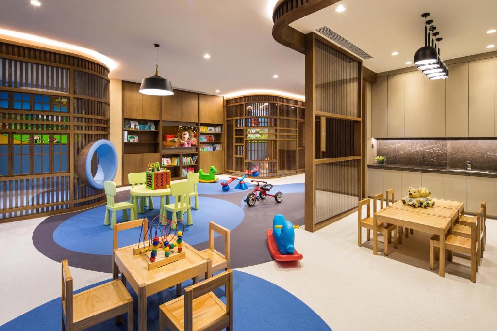 a childrens room with tables and chairs and a play area at Ascott Riverside Garden Beijing in Beijing