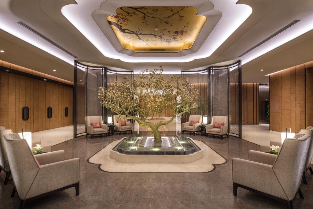a lobby with a fountain with a tree in it at Ascott Riverside Garden Beijing in Beijing