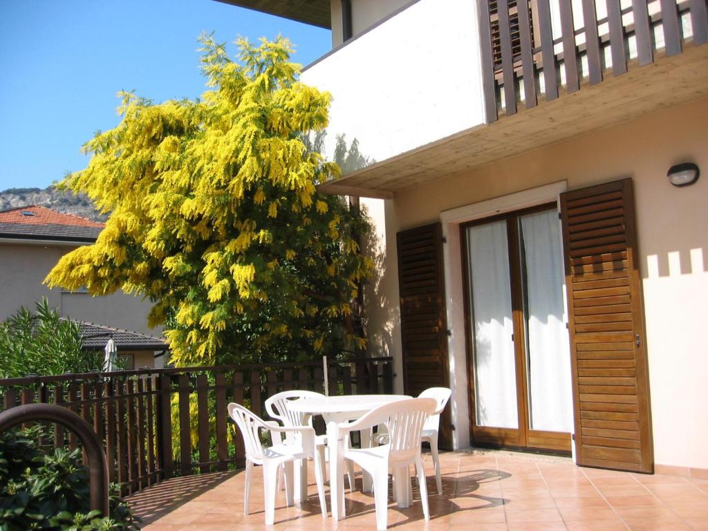 einen weißen Tisch und Stühle auf einer Terrasse in der Unterkunft Casa Martinelli in Nago-Torbole