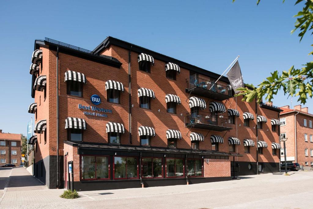 un edificio de ladrillo rojo con sombrillas blancas. en Best Western Hotell Hudik, en Hudiksvall