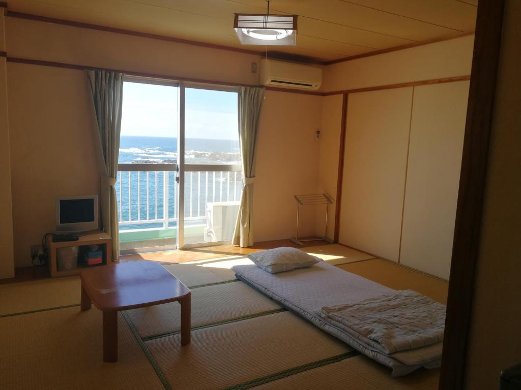 Postel nebo postele na pokoji v ubytování 海のお宿