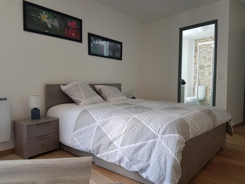 1 dormitorio con 1 cama con edredón blanco en Les Chambres d'Orsay, en Orsay
