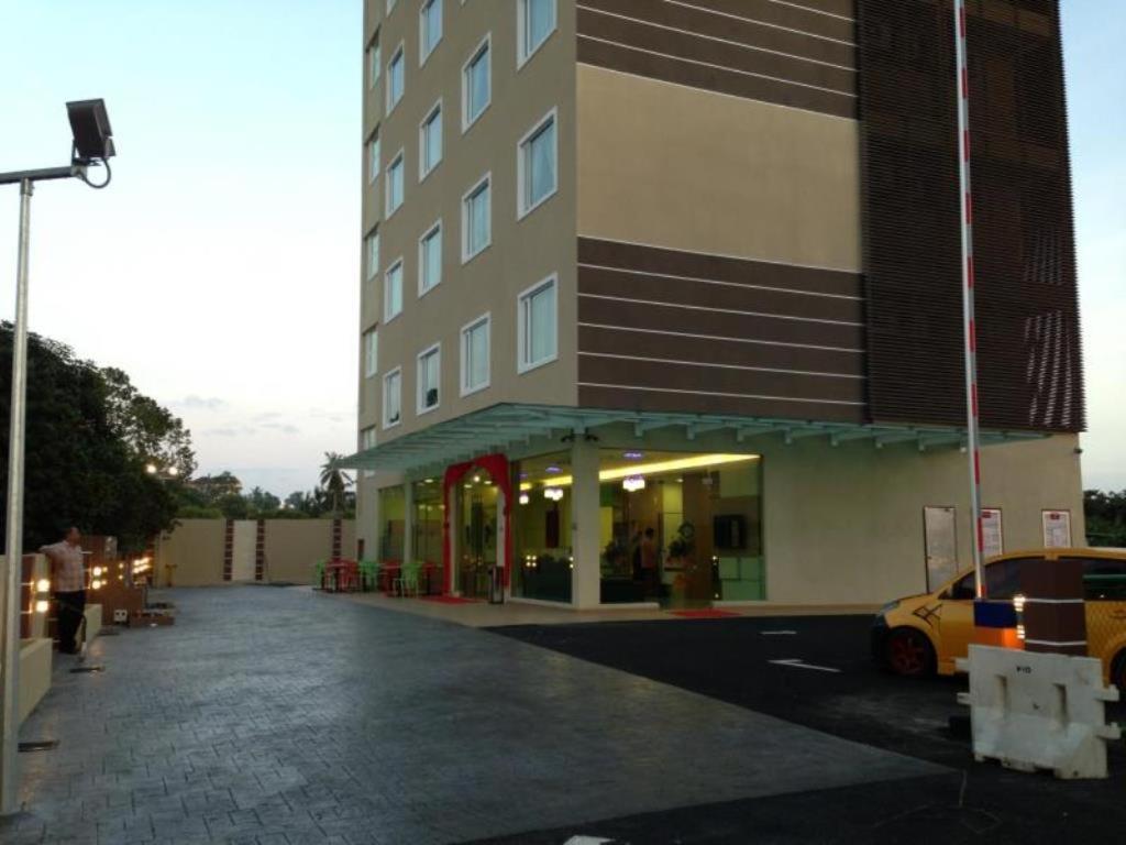 um edifício com um carro estacionado em frente em Caspari Hotel em Tampin