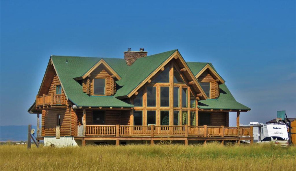 a large wooden house with a green roof at Teton Hostel HideAway in Driggs