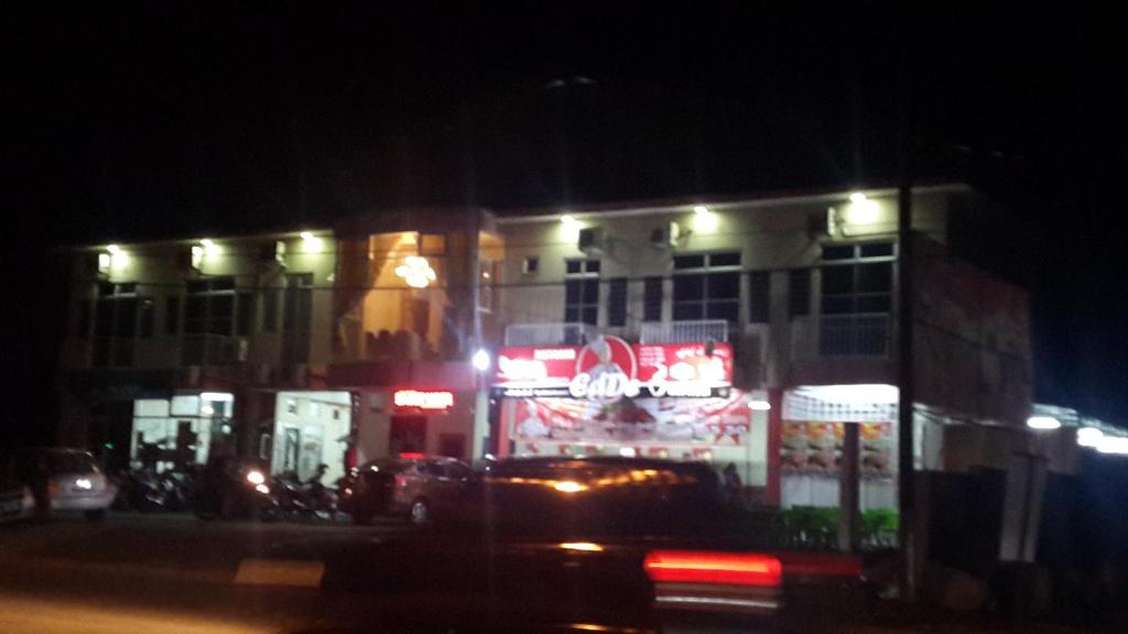 a building with neon signs in front of it at night at Daisyinn Budget Hotel Kuala Terengganu in Kampong Gong Badak