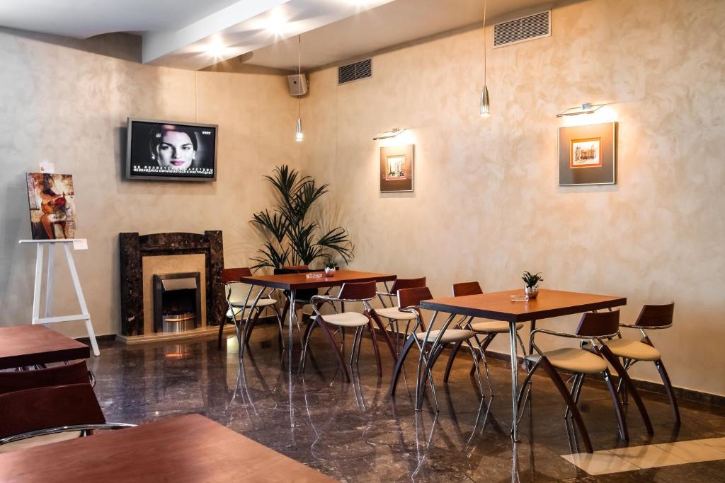 a restaurant with tables and chairs and a fireplace at Alexandrovsky Garden in Nizhny Novgorod